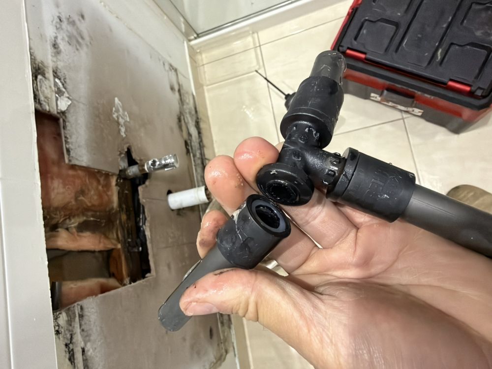 Failed REHAU pipe fitting removed from concealed hot water pipework in Berwick