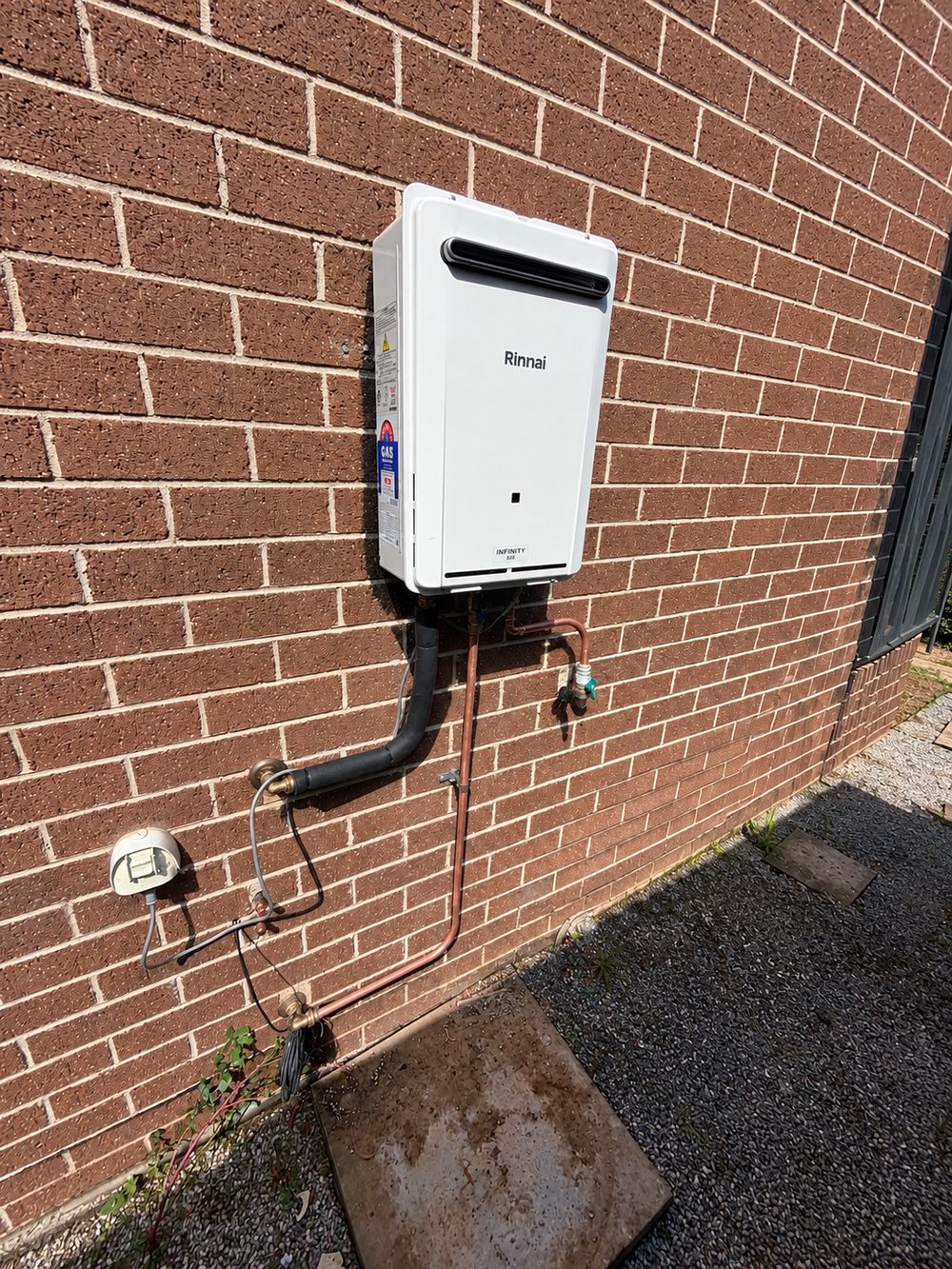 Rinnai Infinity B26 continuous flow gas hot water system installed on brick wall in Rowville