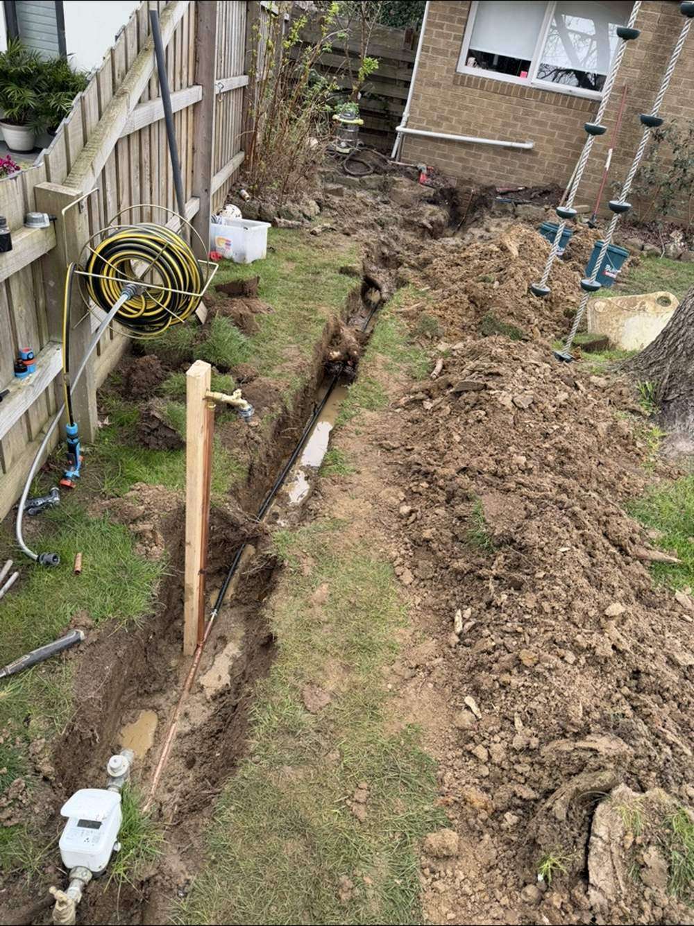 Excavated trench with new water line being installed in Wantirna